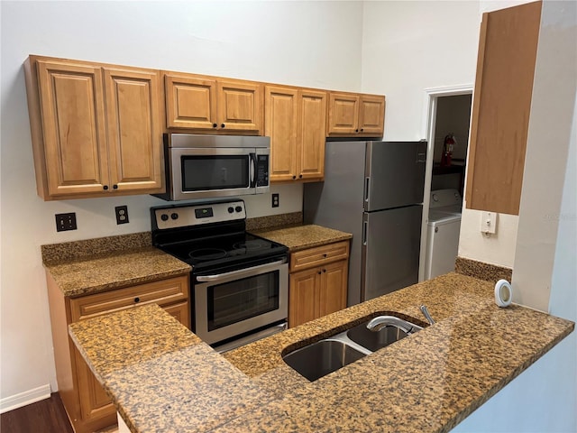 2516 Grassy Point Dr Unit 210, Lake Mary, FL 32746 - kitchen featuring stainless steel appliances, washer / dryer, a sink, and brown cabinetry