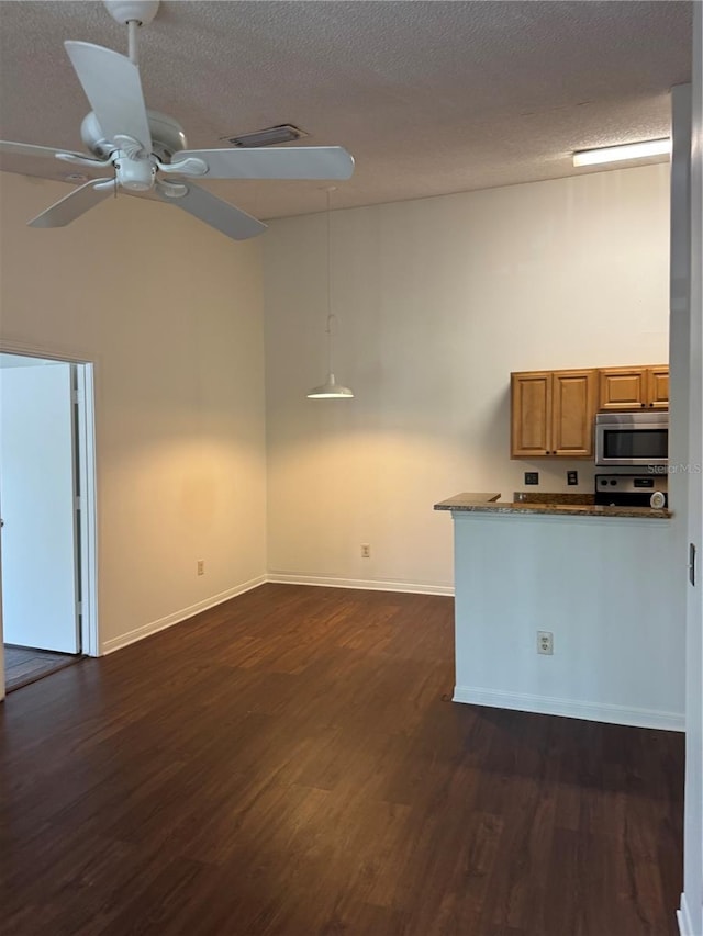2516 Grassy Point Dr Unit 210, Lake Mary, FL 32746 - kitchen featuring stainless steel microwave, dark wood-style floors, brown cabinetry, baseboards, and ceiling fan