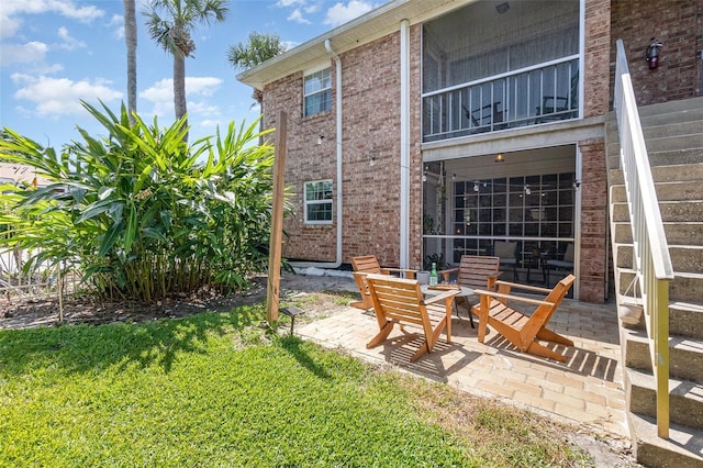 4332 Lake Underhill Rd Unit 12D10, Orlando, FL 32803 - back of house featuring a lawn, brick siding, a balcony, and a patio area