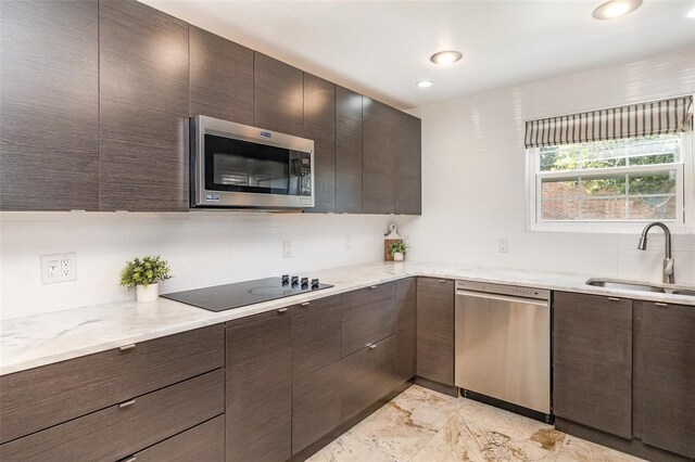 4332 Lake Underhill Rd Unit 12D10, Orlando, FL 32803 - kitchen with dark brown cabinetry, appliances with stainless steel finishes, a sink, and modern cabinets