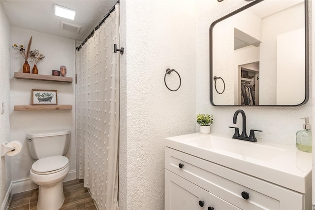 4332 Lake Underhill Rd Unit 12D10, Orlando, FL 32803 - bathroom with vanity, visible vents, a textured wall, wood finished floors, and toilet