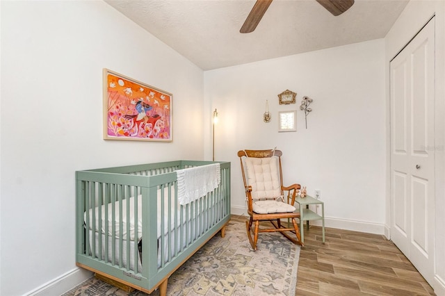 4332 Lake Underhill Rd Unit 12D10, Orlando, FL 32803 - bedroom with a ceiling fan, a nursery area, wood finished floors, baseboards, and a closet
