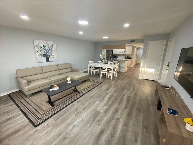 3147 Britannia Blvd Unit A, Kissimmee, FL 34747 - living room with baseboards, recessed lighting, wood finished floors, and visible vents