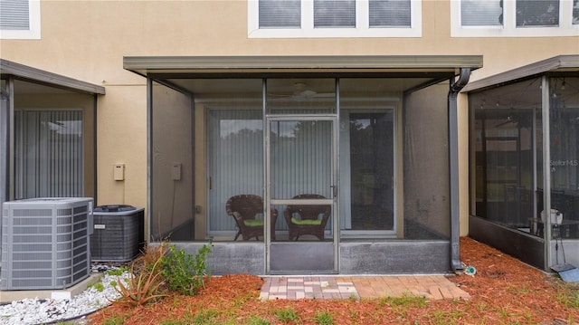 3567 Shallot Dr Unit 103, Orlando, FL 32835 - back of house with stucco siding, a sunroom, and central AC