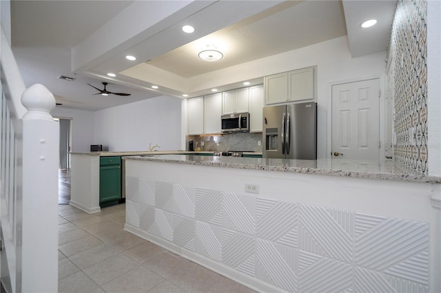 3567 Shallot Dr Unit 103, Orlando, FL 32835 - kitchen featuring appliances with stainless steel finishes, a peninsula, light tile patterned flooring, tasteful backsplash, and recessed lighting