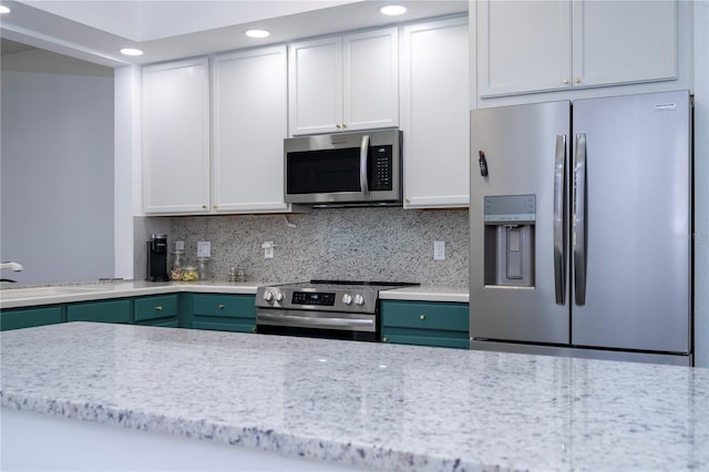 3567 Shallot Dr Unit 103, Orlando, FL 32835 - kitchen featuring appliances with stainless steel finishes, a sink, recessed lighting, decorative backsplash, and white cabinets