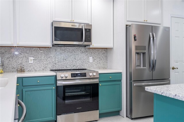 3567 Shallot Dr Unit 103, Orlando, FL 32835 - kitchen featuring stainless steel appliances, backsplash, light tile patterned floors, and white cabinetry