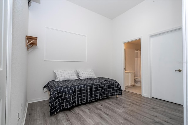3567 Shallot Dr Unit 103, Orlando, FL 32835 - bedroom featuring wood finished floors, ensuite bathroom, and baseboards