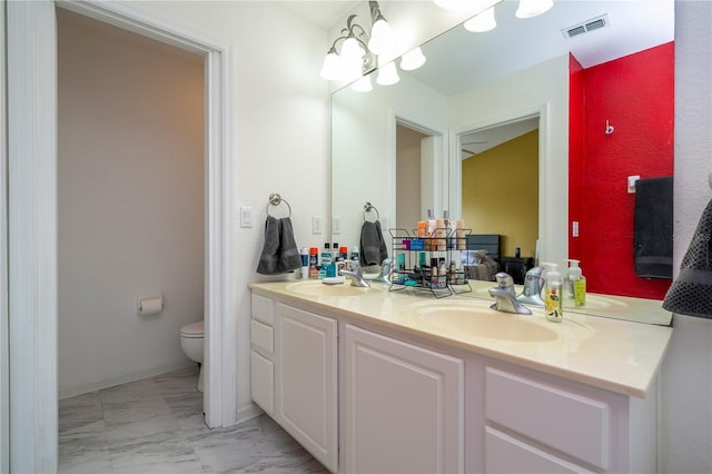 3567 Shallot Dr Unit 103, Orlando, FL 32835 - bathroom featuring toilet, marble finish flooring, and double vanity