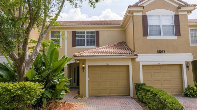 3567 Shallot Dr Unit 103, Orlando, FL 32835 - townhome / multi-family property with a tiled roof, decorative driveway, and stucco siding