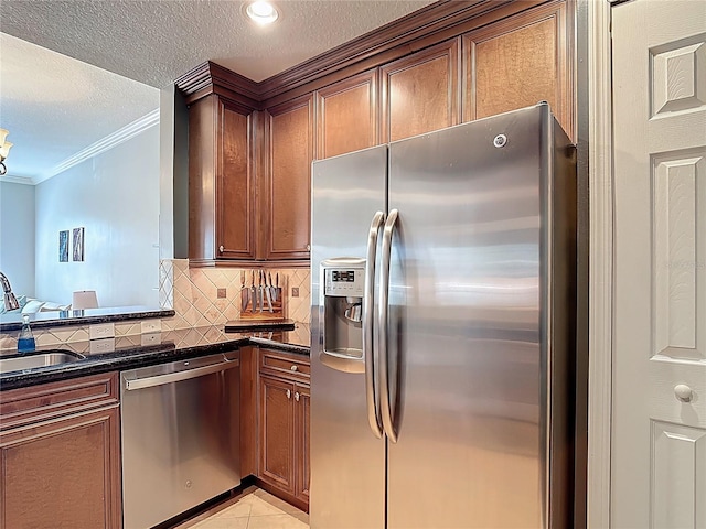 7509 Mourning Dove Cir Unit 203, Reunion, FL 34747 - kitchen featuring crown molding, a textured ceiling, a sink, appliances with stainless steel finishes, and backsplash