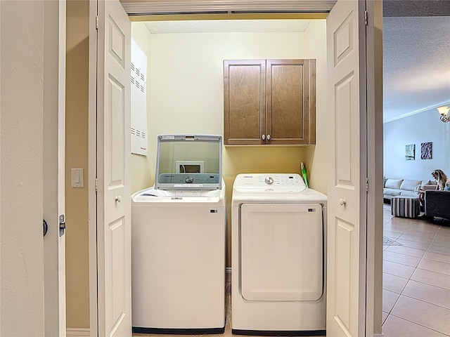 7509 Mourning Dove Cir Unit 203, Reunion, FL 34747 - laundry area featuring separate washer and dryer, a textured ceiling, cabinet space, and light tile patterned flooring