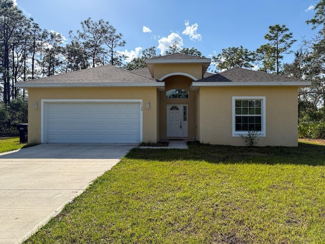 view of front of property with concrete driveway, an attached garage, a front yard, and stucco siding