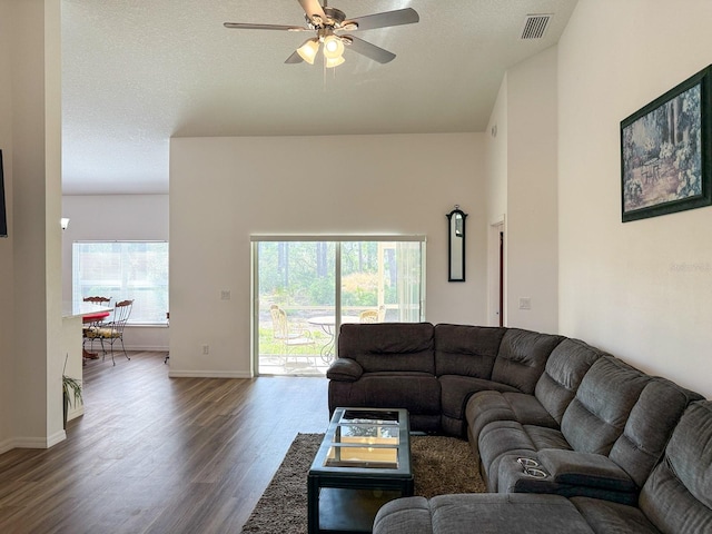living area featuring baseboards, ceiling fan, dark wood finished floors, and visible vents