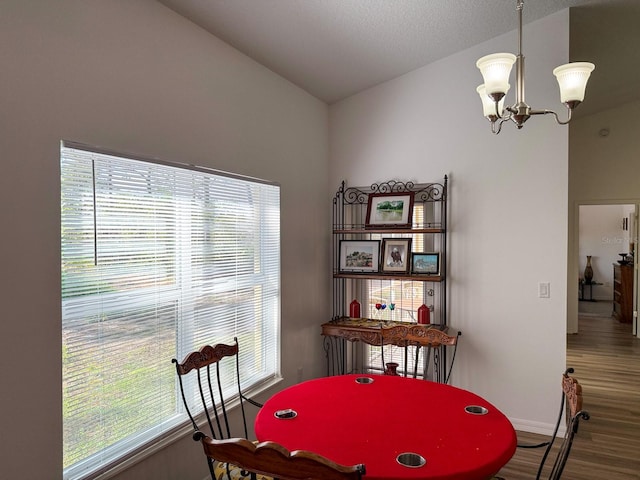 game room with baseboards, a notable chandelier, wood finished floors, and a healthy amount of sunlight