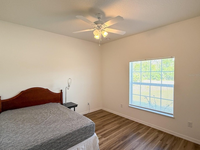 bedroom featuring baseboards, ceiling fan, and wood finished floors