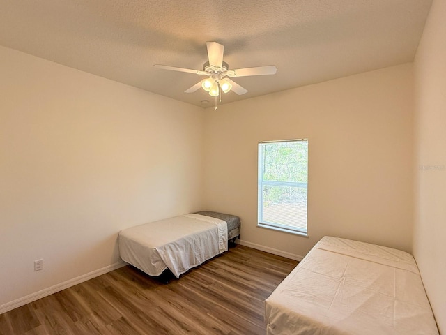 bedroom with baseboards, a ceiling fan, and wood finished floors