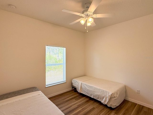 bedroom with baseboards, a ceiling fan, and wood finished floors