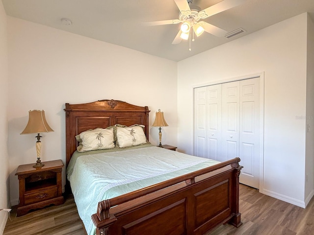bedroom with a ceiling fan, visible vents, light wood-type flooring, baseboards, and a closet