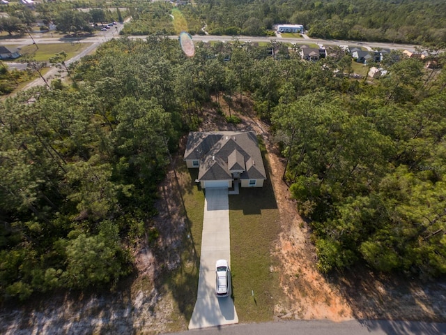 birds eye view of property featuring a forest view