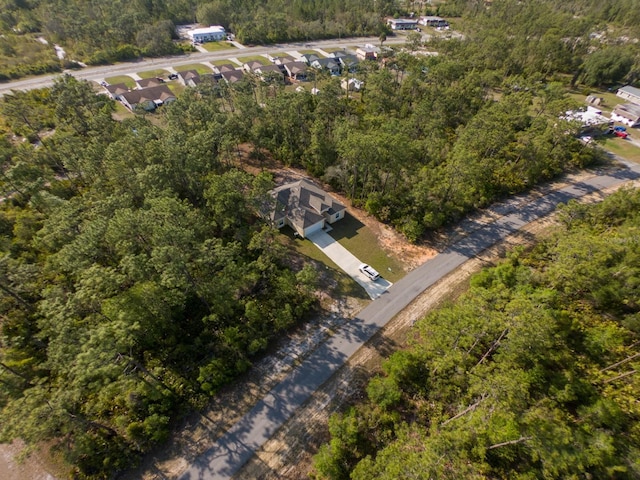 birds eye view of property featuring a view of trees