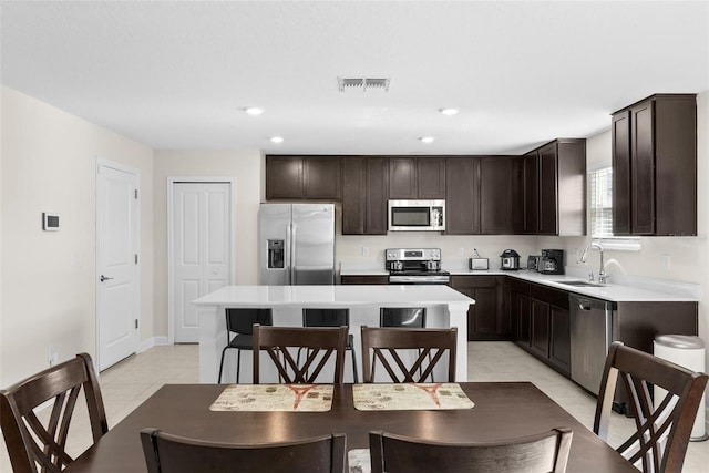 740 Simone Ct, Haines City, FL 33844 - kitchen with dark brown cabinets, appliances with stainless steel finishes, a sink, a kitchen island, and visible vents