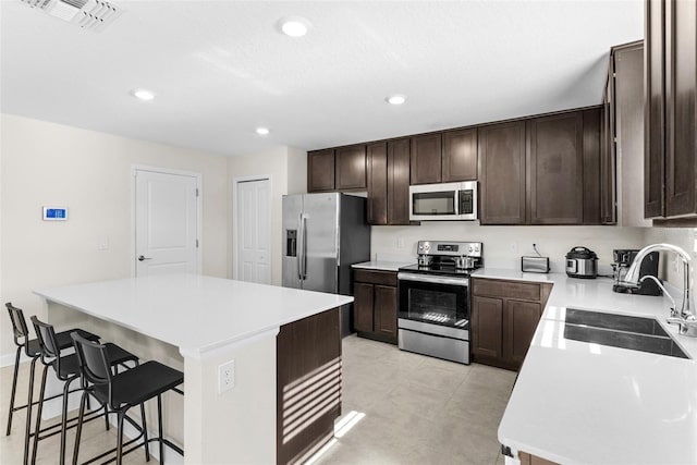 740 Simone Ct, Haines City, FL 33844 - kitchen featuring a kitchen breakfast bar, dark brown cabinetry, visible vents, appliances with stainless steel finishes, and a sink