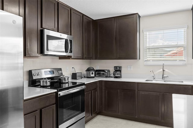 740 Simone Ct, Haines City, FL 33844 - kitchen with a sink, appliances with stainless steel finishes, dark brown cabinetry, and light countertops