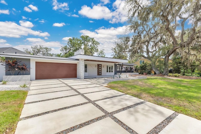 2525 Venetian Way, Winter Park, FL 32789 - contemporary home featuring an attached garage, a front lawn, stucco siding, a porch, and driveway