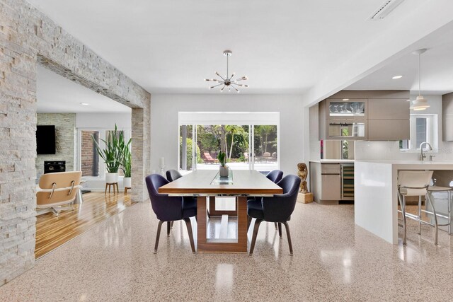 2525 Venetian Way, Winter Park, FL 32789 - dining space featuring a fireplace, wine cooler, a chandelier, and light speckled floor