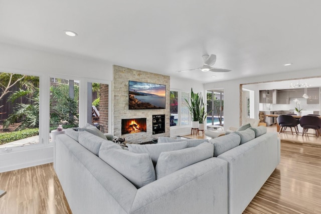 2525 Venetian Way, Winter Park, FL 32789 - living room featuring a healthy amount of sunlight, ceiling fan, light wood-type flooring, and a stone fireplace