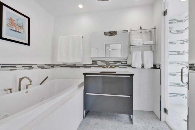 2525 Venetian Way, Winter Park, FL 32789 - bathroom with vanity, tile patterned floors, tile walls, a tub with jets, and tiled shower