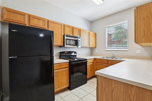 kitchen featuring a sink, light countertops, light tile patterned floors, and black appliances