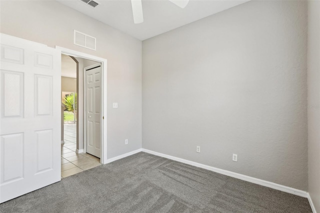 carpeted spare room featuring a ceiling fan, baseboards, and visible vents