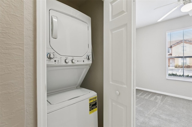 laundry area with laundry area, stacked washer and clothes dryer, baseboards, a ceiling fan, and carpet