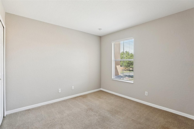 carpeted spare room with baseboards