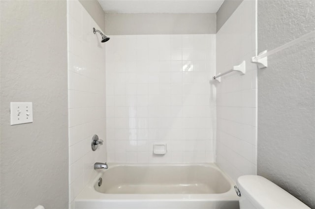 full bathroom with shower / bath combination, a textured wall, and toilet