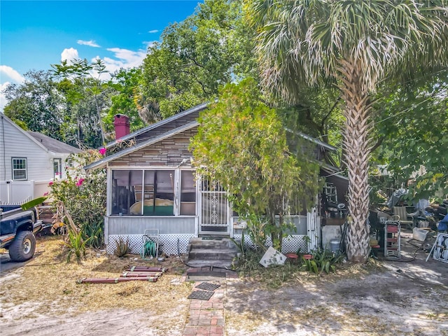 1314 S Mellonville Ave, Sanford, FL 32771 - view of front of house with a chimney, entry steps, and a sunroom