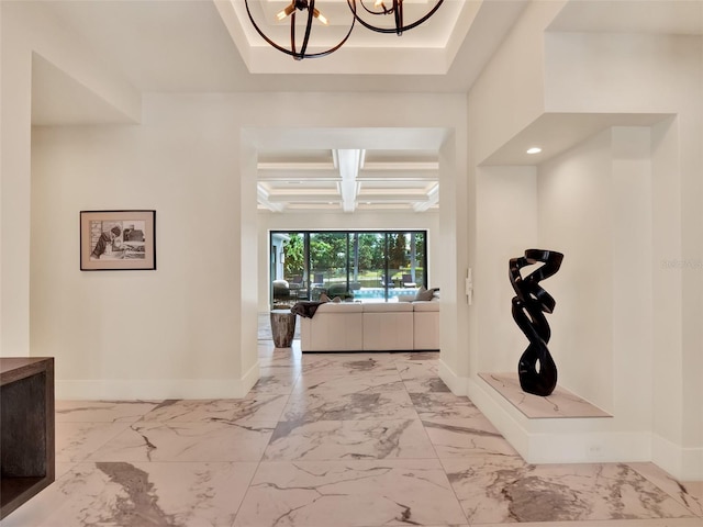 entrance foyer featuring baseboards, a notable chandelier, coffered ceiling, and marble finish floor