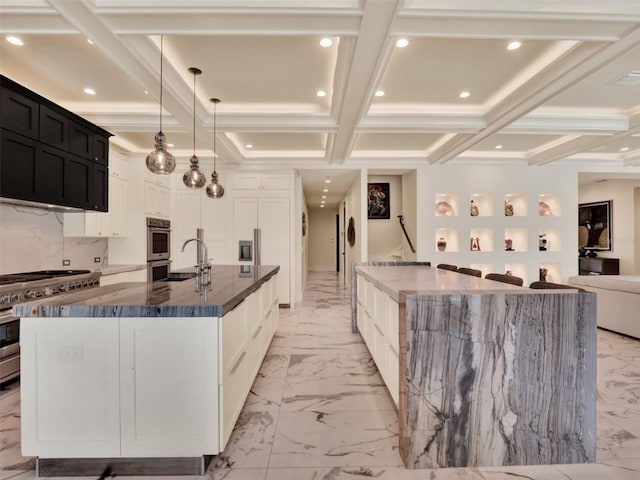 kitchen with a sink, appliances with stainless steel finishes, a spacious island, and marble finish floor