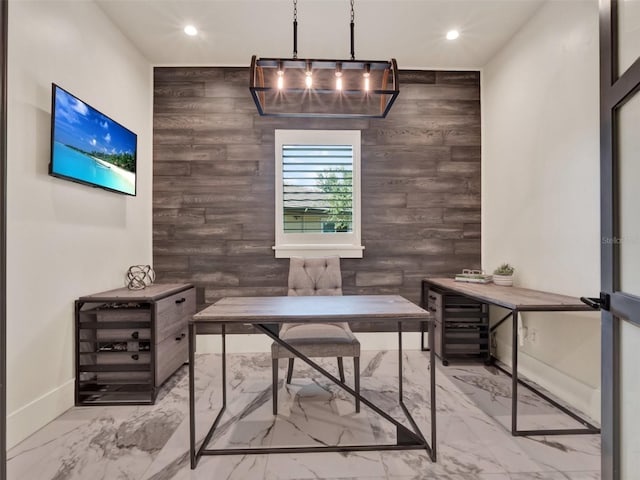 office space featuring marble finish floor, an accent wall, baseboards, wooden walls, and recessed lighting