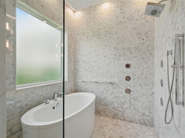 full bath with a freestanding tub, tile patterned floors, and tiled shower
