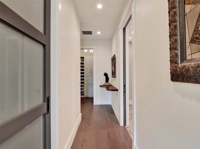 corridor with recessed lighting, baseboards, visible vents, and wood finished floors