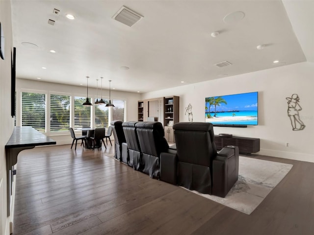 home theater room featuring visible vents, recessed lighting, baseboards, and wood finished floors
