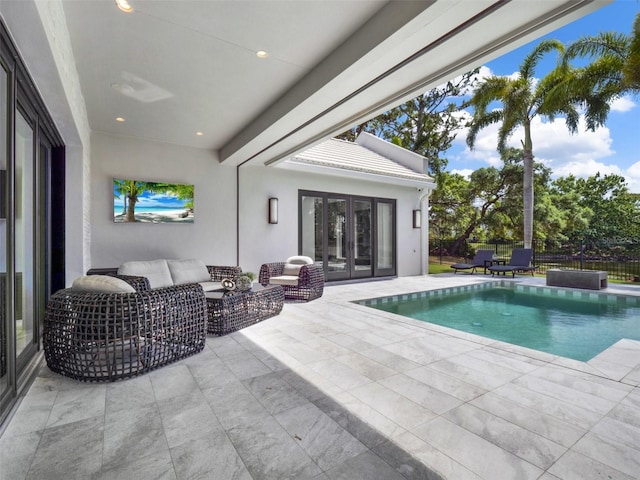 view of pool featuring outdoor lounge area, fence, french doors, a fenced in pool, and a patio area