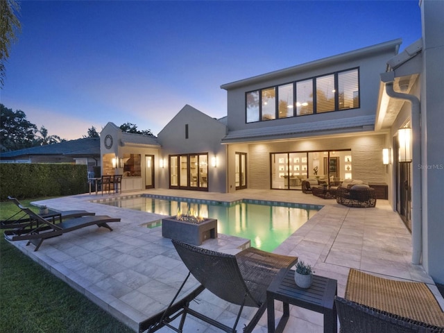 rear view of property with a patio, an outdoor pool, and outdoor dining space
