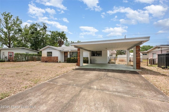 view of front of property featuring fence, a carport, driveway, and a front yard