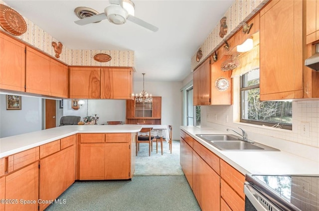 kitchen featuring a sink, ceiling fan with notable chandelier, tasteful backsplash, and light countertops
