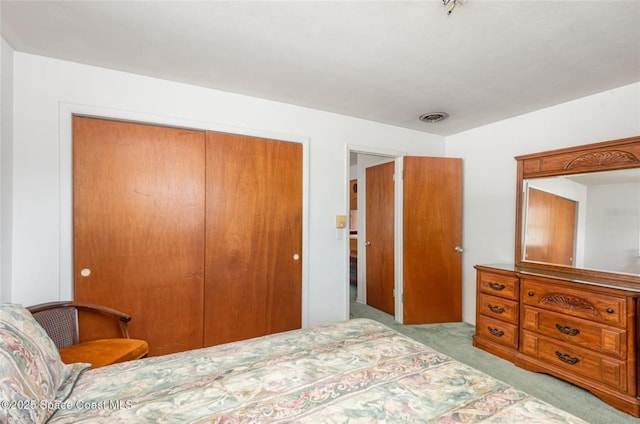 carpeted bedroom featuring a closet and visible vents