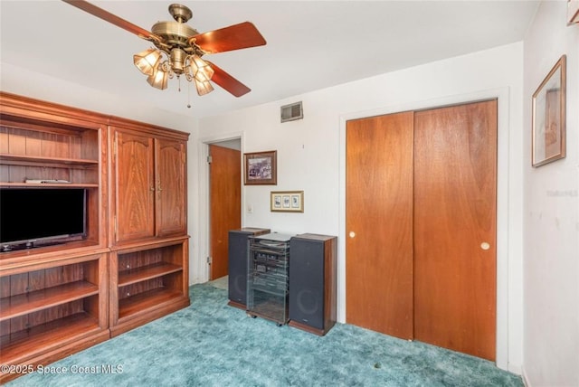 carpeted bedroom with visible vents, ceiling fan, and a closet